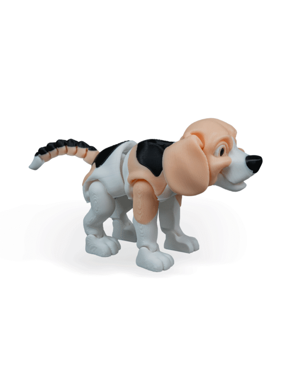 Zabawka z druku 3D przedstawiająca psa rasy beagle w widoku z prawego profilu. Piesek ma duże, oklapnięte beżowe uszy, biały pysk z czarnym nosem i charakterystyczne czarne plamy na grzbiecie. Jego ogon składa się z segmentów w kolorach beżowym i czarnym, co nadaje mu elastyczności. Zabawka stoi na czterech łapach, z przednią łapą lekko uniesioną do przodu.