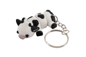 Arletta miniz brelok krowa z druku 3D – biało-czarna leżąca krówka z różowym pyszczkiem i metalowym kółkiem do kluczy