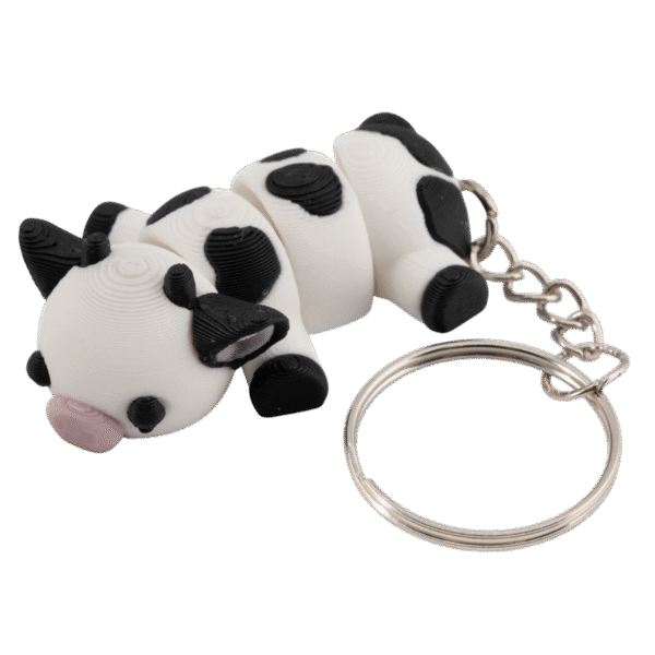 Arletta miniz brelok krowa z druku 3D – biało-czarna leżąca krówka z różowym pyszczkiem i metalowym kółkiem do kluczy