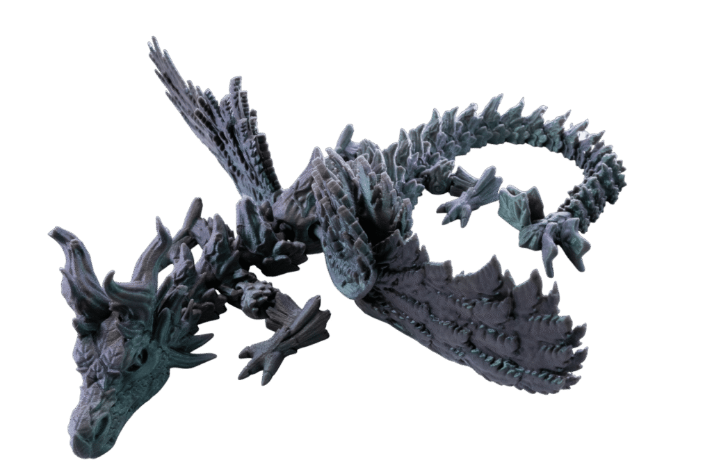 Drago – smok figurka z druku 3D w ciemnozielono-szarym kolorze z turkusowymi refleksami. Widok z góry pokazuje masywne ruchome skrzydła rozłożone szeroko, kolce wzdłuż grzbietu i ogona, detale łusek na całym ciele, muskularne łapy z pazurami. Wysokość 56 cm.
