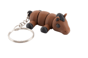 brelok koń z druku 3d w stylu miniz, mały brązowy konik o segmentowym ciele z czarną grzywą i kopytami, leżący przodem do obserwatora, z dużym metalowym kółkiem do kluczy po lewej stronie