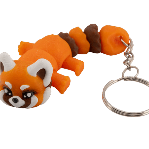 brelok panda ruda z druku 3d w wersji miniz, w żywym pomarańczowym kolorze, z kremowo-białymi uszami i policzkami oraz brązowymi akcentami na pyszczku; model leży w pozycji przodem do obiektywu, z dużymi, błyszczącymi oczami w stylu kawaii, okrągłą głową i segmentowanym ciałem składającym się z kilku ruchomych części; na końcu breloka znajduje się metalowy łańcuszek i kółko do kluczy; całość ma miękki, uroczy charakter typowej pandy rudej