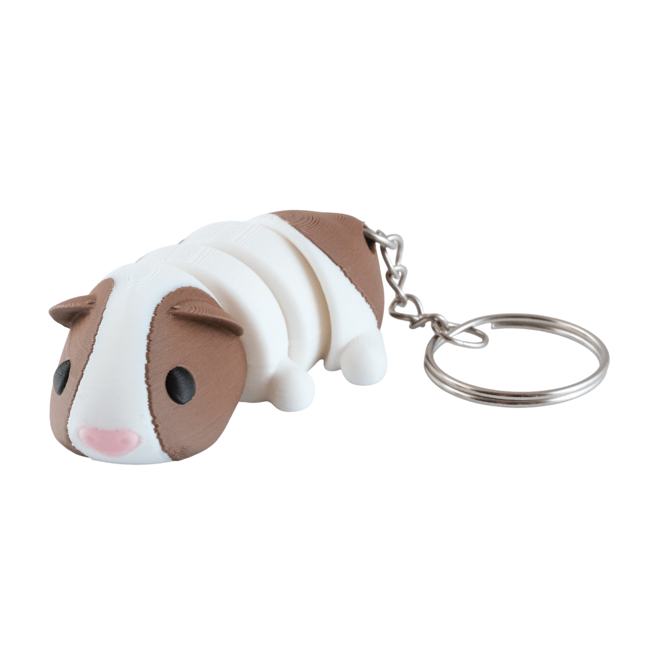 Malinka – miniz brelok świnka morska z druku 3d 1 Miniz brelok świnka morska z druku 3D w kolorze biało-brązowym, różowy nosek, czarne oczy, metalowe kółko na klucze