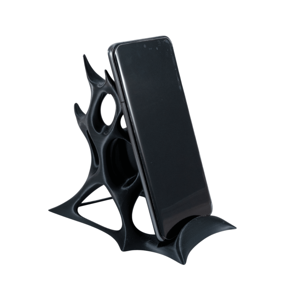 Wełnom czarny stojak na telefon z druku 3D o organicznym kształcie przypominającym symbionta, trzymający smartfon