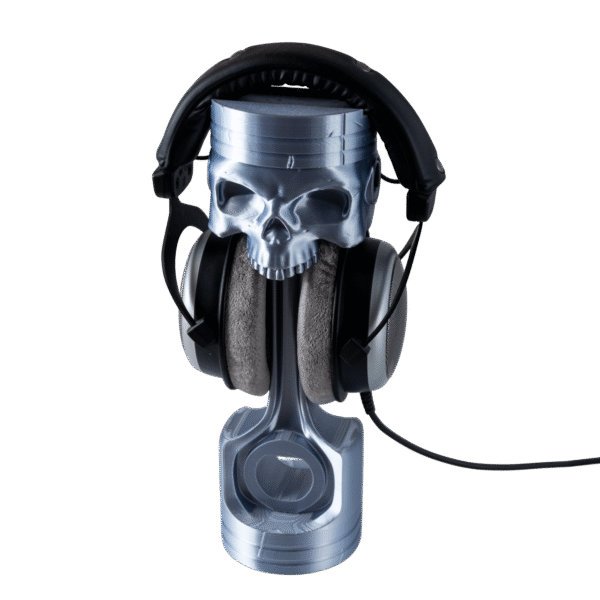 Czachotłok stojak na słuchawki czaszka z druku 3D. Biała czaszka na wysokiej, czarnej podstawie do zawieszania sprzętu.